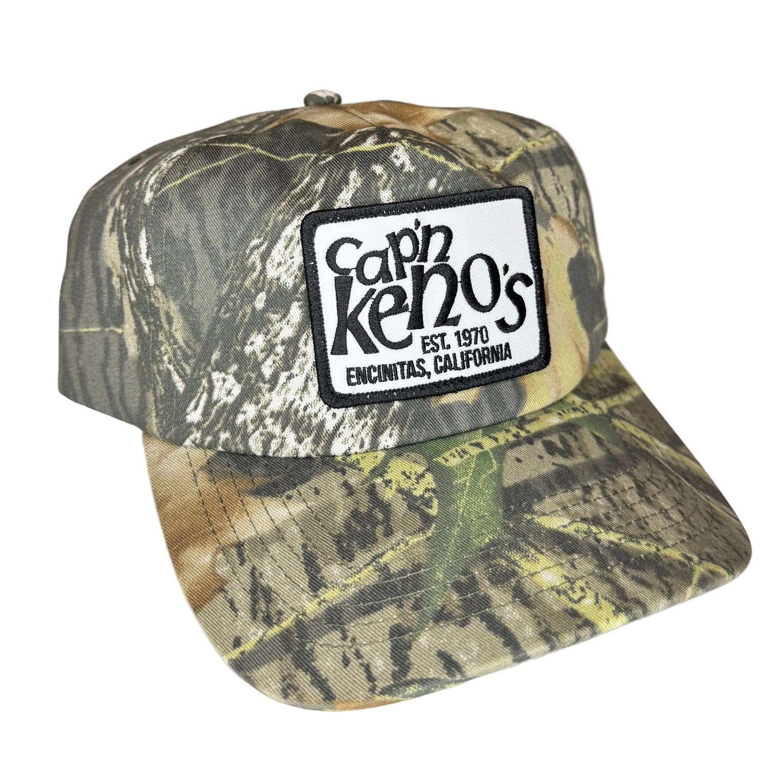 Camouflage cap with 'Cap'n Keno's' logo patch on a white surface,